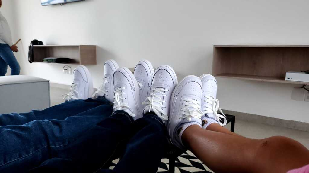 Niñas y niños usando tenis blancos fabricados por Nadú